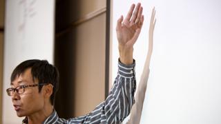 Close up image of a professor at a whiteboard.